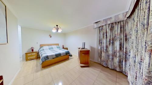 阿尔加罗沃Altos de San Alfonso的一间卧室配有床和带窗帘的窗户