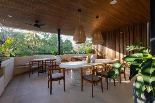诺萨拉Silvestre Nosara Hotel & Residences的餐厅设有木制天花板和桌椅