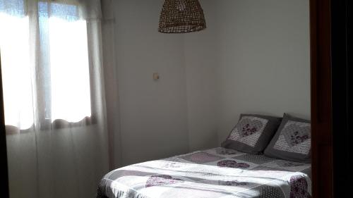 艾格伦Appartement à la campagne的一间小卧室,配有一张带窗户的床