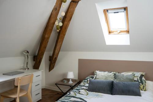 拉瓦勒Chez Nous Laval的一间卧室配有一张床、一张书桌和一个窗户。