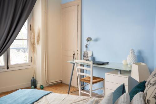 拉瓦勒Chez Nous Laval的一间卧室配有书桌、一张床和一张书桌