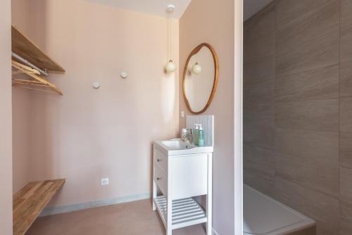 讷韦尔"Le Majorelle" logement atypique en hyper centre, avec service premium by PRIMO C0NCIERGERIE的一间带镜子和白色橱柜的浴室