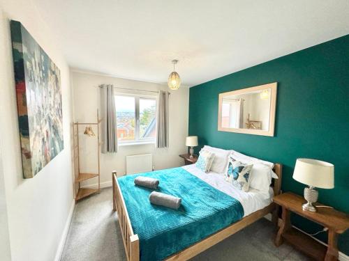 福克斯通3 Bedroom Home centrally located in Folkestone, great location for contractors or families with parking的一间卧室配有一张蓝色墙壁的床