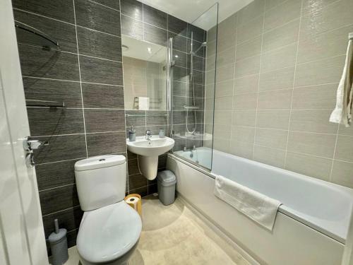 福克斯通3 Bedroom Home centrally located in Folkestone, great location for contractors or families with parking的浴室配有卫生间、盥洗盆和浴缸。