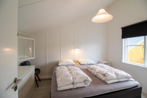 埃贝尔托夫特Perle Øer Maritime ferieby Ebeltoft的白色墙壁客房的两张床