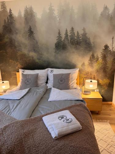 伊斯泰布纳OWCZA GÓRKA Apartamenty的卧室配有一张壁挂森林壁画的床