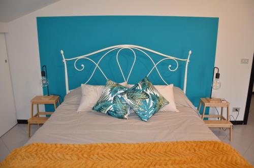 Piobesi dʼAlbaCasa Framama的一张带蓝色床头板的床铺,上面有两个枕头