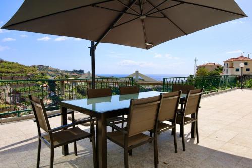 卡马拉-德洛布什Villas Quinta da Lapa by AnaLodges的阳台配有桌椅和遮阳伞