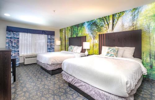 弗里波特Casco Bay Inn的酒店客房设有两张床,墙上挂有绘画作品