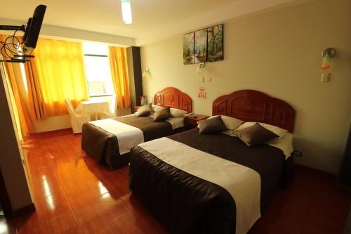 塔克纳Hotel Frontera的酒店客房设有两张床和窗户。