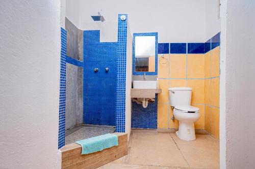 坎昆Casa Playa Hermosa的蓝色瓷砖浴室设有卫生间和水槽