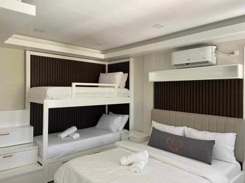 长滩岛Grospe Resort Boracay的卧室配有2张双层床和白色床单
