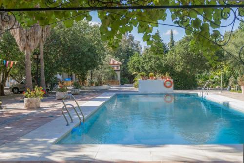 贝纳卢普-卡萨斯维耶哈斯洛斯蒙特洛斯农庄酒店的一座树木繁茂的庭院内的游泳池