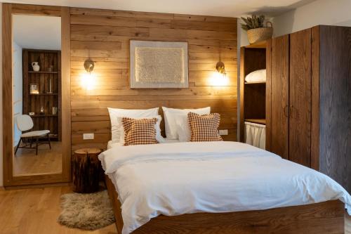 KuterevoGuest Accommodation Butina的一间卧室配有一张带木墙的大床