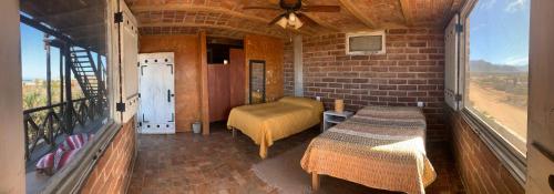 El PescaderoBaja69 lodge的小房间设有一张床和一个阳台