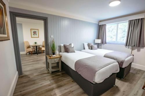 格雷夫森德贝斯特韦斯特庄园酒店的酒店客房设有两张床和一张桌子。