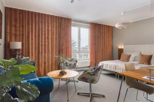 卡尔斯塔德Best Western Hotel River C的酒店客房带一张床、一张桌子和椅子