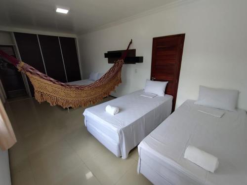 维索萨-杜塞阿拉VIVENDA JUAREZ的客房设有两张床和吊床。