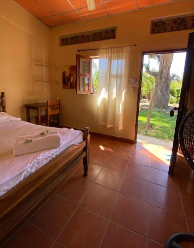 里瓦斯Hostal Casa Bonita Ometepe的一间卧室设有一张床和一个滑动玻璃门