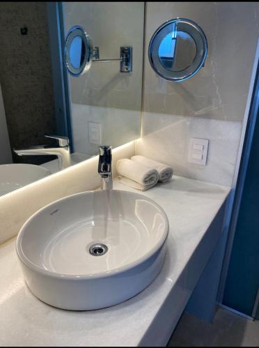 里约热内卢Apart Hotel的浴室设有白色水槽和镜子