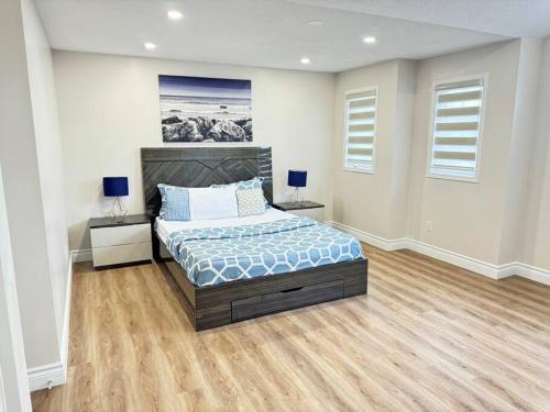 基奇纳Luxury Private home near Sunrise Shopping Complex的一间卧室设有床、两张桌子和两个窗户。