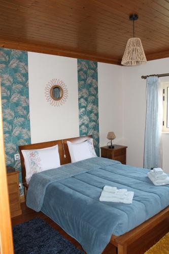 Alqueidão da SerraCasa das Laranjeiras的一间卧室配有蓝色的床和毛巾