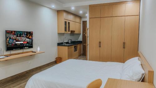 河内Yen’s House的一间小卧室,配有白色的床和电视