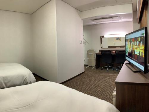 上越市Hotel Alpha-One Joetsu的酒店客房设有两张床和一台平面电视。