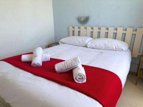 瓦伦西亚Barraca Suites的红色毯子上带三条毛巾的床