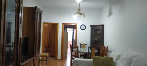 布尔吉略斯ALBORADA TRES的客厅配有桌子和墙上的时钟