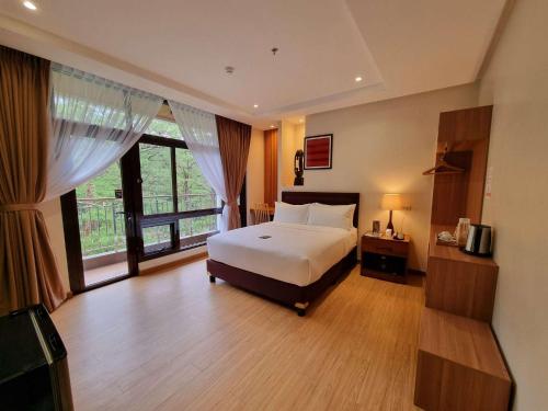 碧瑶Alvea Hotel and Residences的一间卧室设有一张床和一个大窗户