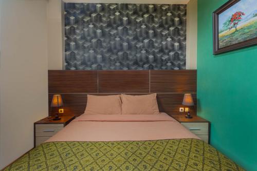 梭罗Hotel DMadinah inn Gentan的一间卧室配有一张大床和两盏灯。