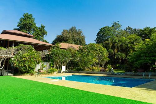 崇贞夫The Hub Erawan Resort的后院设有游泳池和绿草