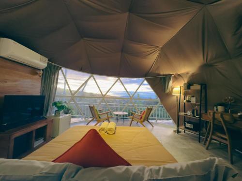 姆杜克Moondock Luxury Camp的一间卧室配有带桌椅的帐篷