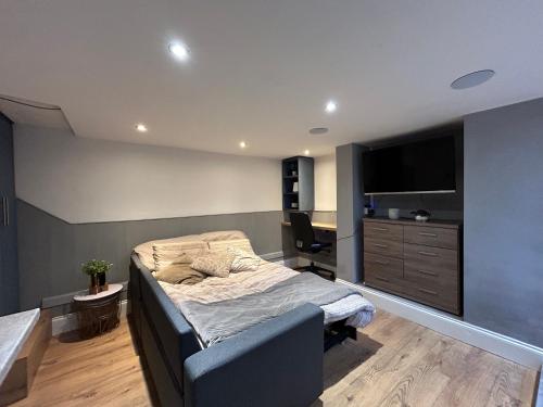 HunsletVOS Lodge Leeds UK的一间卧室配有一张床、一张书桌和一台电视