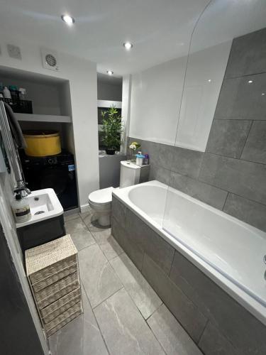 HunsletVOS Lodge Leeds UK的带浴缸、卫生间和盥洗盆的浴室