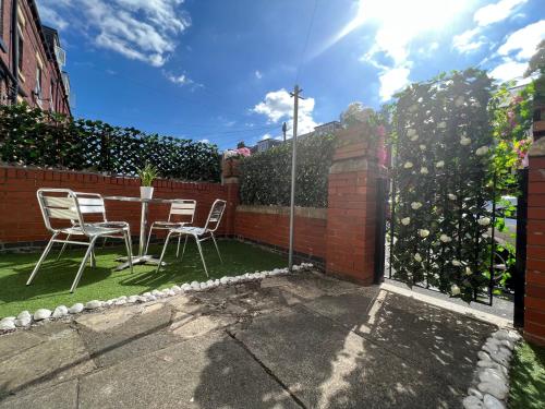 HunsletVOS Lodge Leeds UK的一个带桌椅和围栏的庭院
