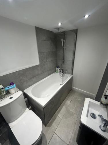 HunsletVOS Lodge Leeds UK的带浴缸、卫生间和盥洗盆的浴室
