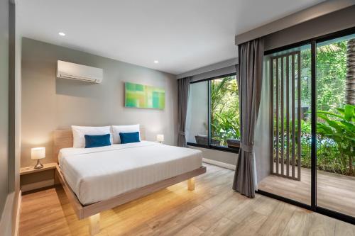 邦涛海滩Diamond Resort Phuket Official Account的一间卧室设有一张床和一个大窗户