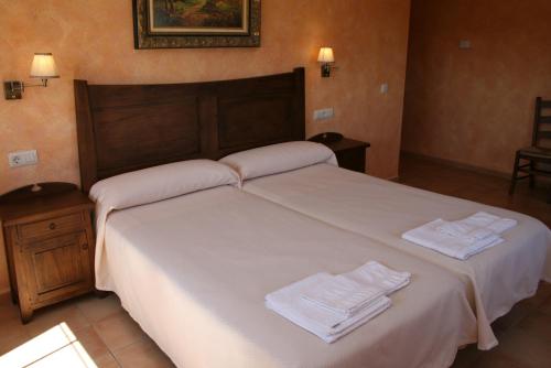 特鲁希略卡萨拉斯维坎特拉斯酒店的一间卧室配有一张带白色毛巾的床