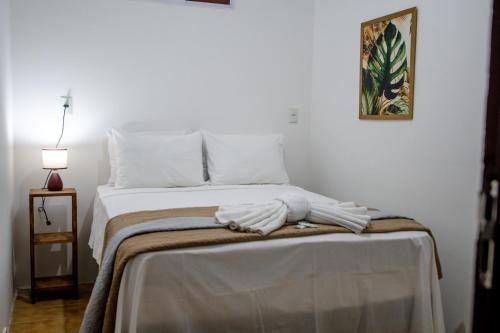 若昂佩索阿Pousada Mangai的一间卧室配有带白色床单和枕头的床。