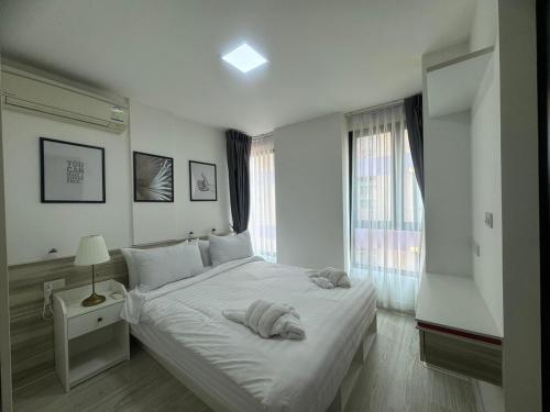 曼那@ style sukhumwit bangna3的白色的卧室设有一张大床和一个窗户