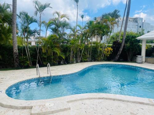 蓬塔卡纳paradise close to the beach pool free parking,wifi- punta cana的棕榈树庭院内的游泳池