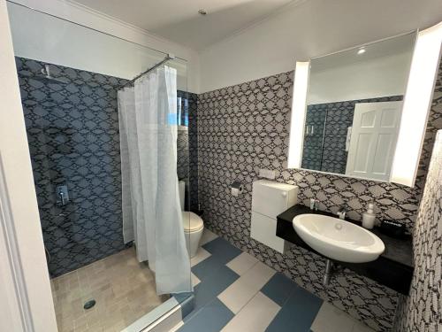 罗索ElDorado Guesthouse的一间带水槽、卫生间和镜子的浴室