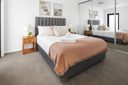 Port AdelaideClare St Apartments by Urban Rest的一间卧室配有两张床和镜子
