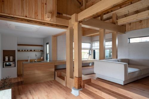 春川Han Yul Jae - Hanok的带沙发的客房以及带木制天花板的厨房