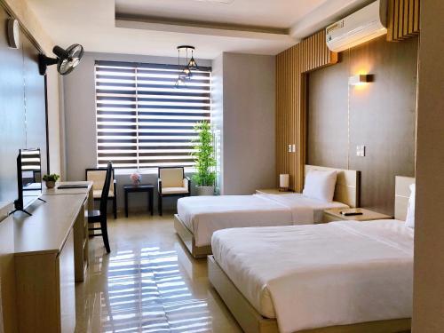 洞海Khách Sạn 20-10的酒店客房配有两张床和一张书桌