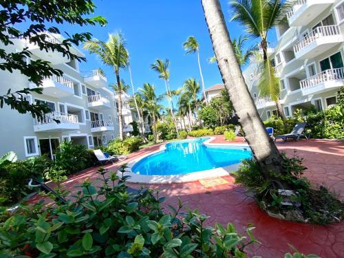 蓬塔卡纳cozy apartment near the beach los corales punta Cana.的大楼前的游泳池