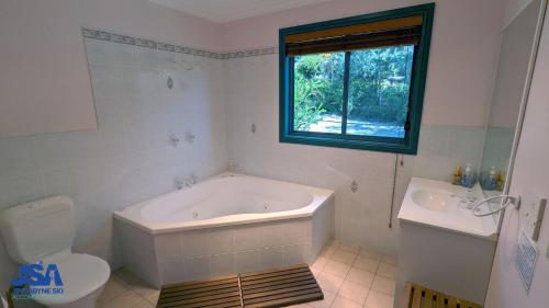 金德拜恩自然景观度假屋的带浴缸、卫生间和窗户的浴室