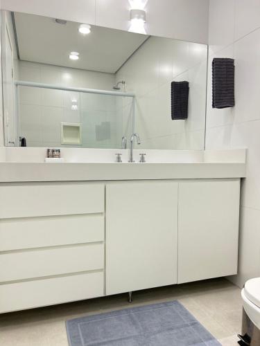 圣保罗Pinheiros Duplex no pool的白色的浴室设有水槽和镜子